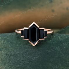 a black diamond ring sitting on top of a green surface