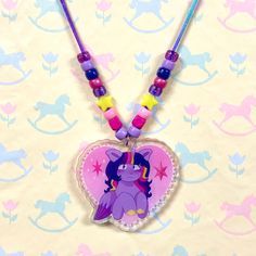 a necklace with an image of a pony sitting on it's side and beads around the neck