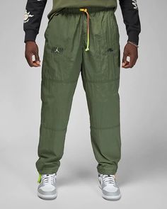 Jordan Flight takes your familiar lightweight woven pants and gets them ready for wet weather. Whether you're chillin' inside or out, you're good to go with a water-repellant finish that'll help you stay dry. Benefits Water-repellent fabric is light, durable and comfortable in wet weather. Fresh graphics combine iconic Jordan looks with energy and color. Product Details Body: 100% nylon. Pocket bags/Lining: 100% polyester. Side pockets and a Zippered back Gradient drawstring Machine wash Importe Trousers Men, Cargo Khaki, Man Weave, Active Wear Pants, Wet Weather, Nike Store, Black Running Shoes, Fleece Joggers, Fashion Updates