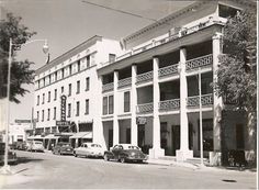 an old black and white photo of cars parked in front of a building