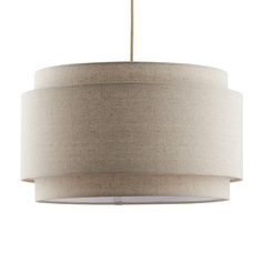 a beige drum light hanging from a ceiling