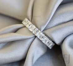 an image of a diamond ring on top of a satin material fabric with diamonds in the middle