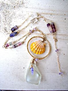 The Sunrise Shell is prized for its rarity. It is found only in the Hawaiian Islands, and rarely found on the beach. Most of them are found by divers, deep in the ocean. My Sunrise Shells are found by my husband and a close family friend. Our Sunrise Shell creations are a true LABOR OF LOVE. From my husband diving to extreme depths to unearth these beauties beneath layers of sand, to the labor-intensive processing of the shell (to remove any natural calcification of the shell), to the final desi Handmade Purple Beach Jewelry, Unique Gemstone Jewelry For The Beach, Unique Beach Glass Jewelry, Unique Glass Jewelry For Beach, Shell Creations, Sunrise Shell, Close Family, Fluorite Stone, Golden Rutilated Quartz