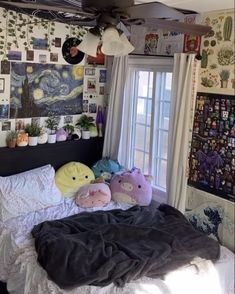 two stuffed animals are on the bed in front of a wall with pictures and paintings