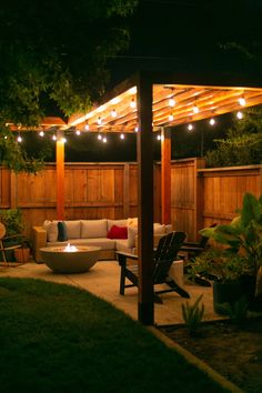 an outdoor living area with patio furniture and string lights on the pergolated roof