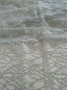 an image of some water and sand with small bubbles on the surface that looks like waves