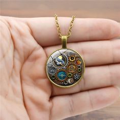 Introducing the Popular Steampunk Mechanical Time Stone Necklace! This fashion-forward statement piece is perfect for steampunk lovers, cosplayers, and industrial enthusiasts Its unique design features intricate Gear-like mechanisms, metallic accents, and beautiful Time Stones for a stylish impact. The necklace is constructed with an adjustable chain for a comfortable fit, while the Time Stones add a touch of personality. Whether for special occasions, costume events, or everyday looks, this Vic Fantasy Style Bronze Metal Necklace, Bronze Metal Fantasy Necklace, Gold Fantasy Necklace In Metal, Steampunk Metal Round Pendant Jewelry, Steampunk Metal Jewelry With Round Pendant, Steampunk Adjustable Necklace With Soldered Details, Retro Soldered Metal Jewelry, Gold Steampunk Necklaces, Gold Steampunk Metal Necklaces