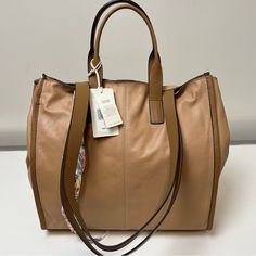 Lucky Brand Dina Leather Tote Bag Outward Facing Seams And A Soft Silhouette Highlight The Versatility Of This Spacious Tote Bag Made From Rich Leather. 10.5" H X 14" W X 5.5" D, 7" Handle Drop, 42" Strap Drop Dual Rolled Top Handles, Optional Crossbody Strap Magnetic Top Closure Interior Has Zip And Slip Pockets Leather Lined Imported Light Brown Hobo Bag For Shopping, Light Brown Tote Hobo Bag For Shopping, Light Brown Hobo Tote Bag For Shopping, Light Brown Shoulder Bag With Handles For Shopping, Light Brown Shoulder Bag For Shopping, Cream Rectangular Bag With Leather Lining, Cream Rectangular Bags With Leather Lining, Designer Beige Hobo Bag With Removable Pouch, Beige Leather Hobo Bag With Adjustable Strap