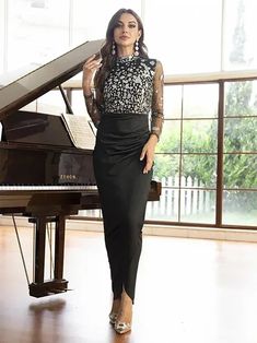 a woman standing in front of a piano