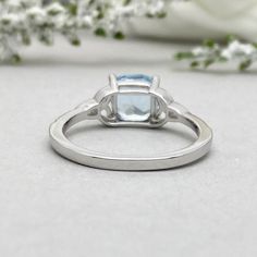 This beautiful ring is made from genuine 925 sterling silver with rhodium plating. Ring details- -The Main stone is a Cushion Cut 7MM Natural Aquamarine Stone -Side stones are 1mm Round simulated diamonds -Ring is casted in solid 925 sterling silver with rhodium plating (yellow gold and rose gold plated also available, please check the drop down menu for more options) -The Total face height of the ring measures 7.5mms and the band width measures 2mms -Each ring is handmade and made to order, so Classic White Gold Diamond Ring With Blue Topaz, Silver Cluster Ring With Birthstone For Anniversary, Fine Jewelry White Gold Blue Topaz Ring, Classic 14k White Gold Topaz Promise Ring, Wedding Blue Topaz Hallmarked Rings, Silver Topaz Ring For Promise, Fine Jewelry, Classic White Gold Birthstone Ring With Blue Topaz, Classic White Gold Blue Topaz Birthstone Ring, Hallmarked Topaz Promise Ring With Round Cut