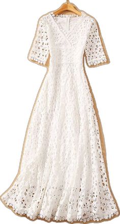 a white dress on a hanger with an openwork pattern and gold trimmings