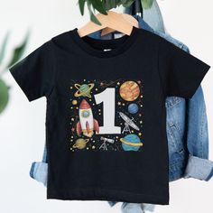 Welcome to Maddy & George Designs! We are excited to present our exclusive collection of baby t-shirts, each meticulously crafted to order. Unlike off-the-shelf products, every t-shirt is individually made with high-quality materials and careful printing techniques to ensure exceptional quality. Since each item is tailor-made for your little one, please allow 3-5 business days for us to prepare your order before shipping. The wait will be well worth it! **Product Information** Our baby t-shirts George Designs, Shelf Products, Space First Birthday, Baby Astronaut, Space Themed Birthday Party, Rocket Birthday, Space Themed Birthday, First Birthday Boy, First Birthday Shirt