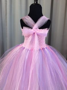 Fuzzy Duckling Design dresses ~ handcrafted for the little princess in your life. Our beautiful dresses feature a stretchy, crocheted bodice that is fully lined for both comfort and modesty. The full skirts sparkle and shine with three layers of high quality tulle in matte, shimmer, and glitter finishes. Satin ribbons, flowers, and jewels are added to make each dress something special. Our standard princess dresses are designed to be tea-length and should reach to approximately mid-calf on your Lavender Fitted Princess Dress For Dress-up, Lavender Princess Dress For Dress-up, Lavender Princess Dress For Dress-up Occasions, Princess Style Lavender Fairy Dress For Party, Pink Fitted Princess Fairy Dress, Fairy Style Pink Princess Wedding Dress, Cute Purple Tulle Fairy Dress, Handmade Fitted Pink Dress, Cute Handmade Pink Dress