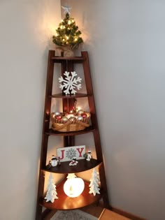 a christmas tree is on top of a corner shelf in the corner of a room