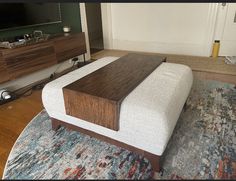 a bed sitting on top of a wooden floor next to a tv mounted above it