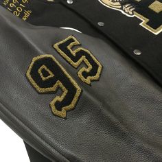 two black and gold leather jackets with the letter s on it's side, sitting next to each other