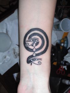 a black and white tattoo on the wrist of a person's arm with an eye