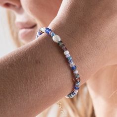 Handmade in our Devon studio, each Surf Rider bracelet is constructed using a mixture of glass beads inspired by the colours of the ocean, as well as gold-plated brass beads and a Freshwater pearl bead central to the design. We have finished the piece with a gold-plated brass clasp and adjuster, so you can be sure the bracelet fits perfectly to your wrist. Our Surf Rider Blue Beaded Bracelet is inspired by time spent surfing on Devon's beaches as well as around the coasts of Europe, and will rem Surf Bead Bracelet, Ocean-inspired Beaded Strand Bracelets As Gift, Surfing Jewelry, Surfing Bracelets, Adjustable Blue Ocean-inspired Bracelet, Surf Bracelet, Surf Jewelry, Gifts For Surfers, Blue Beaded Bracelets