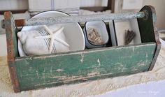 an old wooden crate filled with dishes and seashells