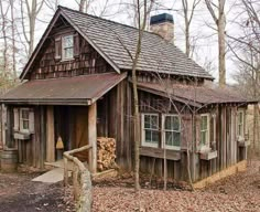 an old log cabin in the woods surrounded by trees and leaves with a chimney on top