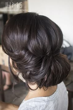 a woman with dark brown hair is looking at the camera and then she's getting her hair done