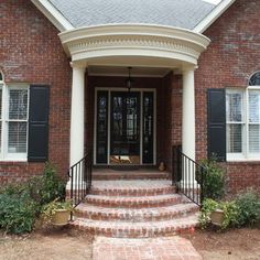 a brick house with steps leading to the front door