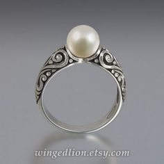 "BEATRICE ring is made to order in 14K gold in the size specified by the customer. The shank is adorned with intricate scroll carvings. The ring features a beautiful 7.5mm White Akoya Pearl. The crown is about 8mm high (including the stone) and 7.5mm wide. The widest part of the shank is 5.9mm. The ring can be made in sizes from 4 to 9. The sample ring shown in the photos is size 6.75. The ring is shown with an antique tarnishing, which adds depth and brings out the beautiful carvings. If you ra