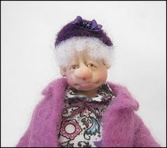 a small doll wearing a purple coat and hat