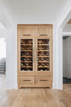 a large wooden cabinet filled with lots of bottles and wine glasses on top of it