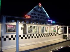 an old fashion frozen custard restaurant is lit up at night with neon lights