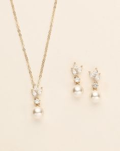 three pieces of jewelry on a white surface, including a necklace and earring set