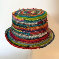 a multicolored hat is sitting on a stand