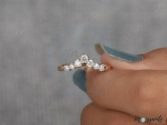 a woman's hand holding a diamond ring