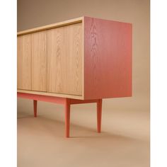 a wooden cabinet sitting on top of a floor next to a white wall and brown floor