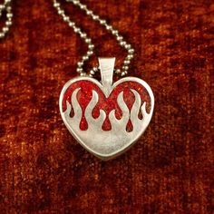 The sterling silver hearts on fire pendant features a chunky design and a stunning ruby red opal inlay (or your chosen inlay). Alternatively, you can opt for a transparent pendant without any inlay. It boasts a substantial 4 mm thickness and stands 26 mm tall. PLEASE READ: The production and delivery of your piece may take anywhere from 2-4 weeks as it is custom made by a real person. Grit Trade Co. is a curated collection of unique sterling silver jewelry inspired by American culture, music, an Red Polished Jewelry For Valentine's Day, Red Heart-shaped Engraved Jewelry, Red Sterling Silver Heart Pendant Jewelry, Unique Red Heart Shaped Jewelry, Red Engraved Heart-shaped Jewelry, Sterling Silver Heart-shaped Jewelry With Large Pendant, Collectible Sterling Silver Jewelry For Valentine's Day, Silver Jewelry With Large Pendant For Valentine's Day, Valentine's Day Silver Jewelry With Large Pendant