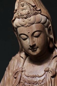 a buddha statue with its eyes closed and head turned to look like she is holding her hands together