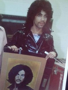 a man holding up a portrait of himself