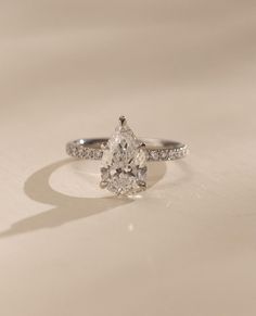 a white gold ring with a pear shaped diamond