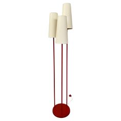 three red and white floor lamps sitting next to each other