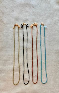 Great for everyday wear! Very tiny and delicate. Muted neutral tones. This tiny necklace is made with high quality Japanese seed beads that are perfect cylinders. Necklace clasp and jump rings are gold plated. Natural silk cord with frayed tassel ends. Available in 4 matte colors: burnt umber, palm, black, and ocean. 📏Not sure which length to choose? Add a chain extender: https://etsy.me/34lPf3m ✨ FREE SHIPPING IN THE USA ✨ 🌎 Packaging 🌎 To be environmentally responsible about packaging we wi Minimalist Adjustable Beaded Necklace With Gold Beads, Adjustable Gold Beaded Everyday Necklaces, Adjustable Gold Beaded Necklaces For Everyday, Handmade Delicate Beaded Necklaces For Everyday, Delicate Handmade Beaded Necklaces, Dainty Adjustable Beaded Necklaces With Faceted Beads, Dainty Adjustable Bracelet With Tiny Beads, Adjustable Everyday Beaded Necklace, Minimalist Adjustable Beaded Necklace With Faceted Beads