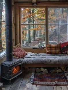 a couch sitting in front of a window next to a wood stove