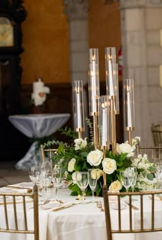 the centerpieces on this table are made from gold metal and have candles in them