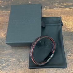 Handcrafted from premium leather Astro is an elegant bracelet, as tough as it looks. Red leather strips weave up and down the wide band, adding a dash of spark. With a minimalistic magnetized stainless steel clasp in black rhodium, it stacks effortlessly with other bracelets and watches, but is substantial enough to hold its own. Premium Nappa Leather Stainless Steel Clasp with Rhodium Bracelet, 10mm Wide Modern Leather Braided Bracelet With Black Band, Modern Braided Leather Bracelets With Black Band, Modern Black Leather Bracelet For Everyday Use, Modern Black Leather Bracelet For Everyday, Modern Black Braided Bracelets As Gift, Modern Black Braided Bracelets For Gift, Modern Black Braided Bracelet Gift, Modern Black Braided Bracelet As Gift, Modern Leather Braided Bracelets