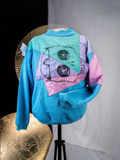 This is a cotton sweater with color blocked nylon paneling, and an original artist print. Individuation in is yours for the taking. Blue Color Block Sweater For Streetwear, Retro Cotton Patchwork Sweatshirt, Blue Patchwork Sweatshirt For Streetwear, Retro Green Patchwork Sweater, Retro Cotton Patchwork Sweater, Retro Patchwork Sweatshirt For Streetwear, Retro Color Block Sweatshirt For Streetwear, Retro Multicolor Graphic Print Sweatshirt, Sporty Cotton Patchwork Sweater