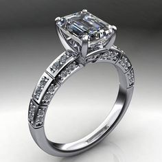 an engagement ring with a princess cut diamond in the center and side stones on the band