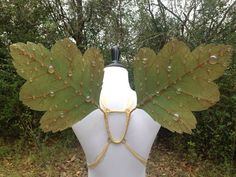 a white mannequin with green leaves on it