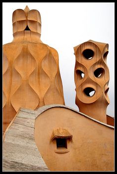 two wooden sculptures are shown on the top of a building with holes in it's roof