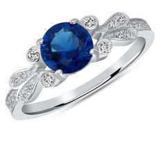 a blue sapphire and diamond ring with white diamonds on the band, set in 18k white gold