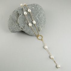 This lariat style white pearl necklace will turn heads. It is simply gorgeous. Made with white freshwater rice pearls that are individually hand wire wrapped onto 14k gold filled chain, and fastens with a 14k gold filled lobster clasp. The necklace showcases a round hammered 14k gold filled connector that sits right at the dip at the bottom of the neck and has a lovely 3.25 inch pearl and chain dangle that drops enticingly down into the décolletage area. A very sexy necklace that will compliment Tin Cup, Pearl Lariat Necklace, Pearl Lariat, Three Necklaces, Rice Pearls, Low Cut Dresses, White Pearl Necklace, Necklace White, Station Necklace