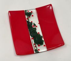 a red and white plate with holly decorations on it